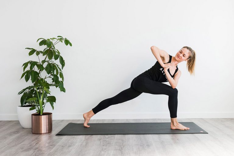 Side angle yoga pose held on a mat in the All for One studio