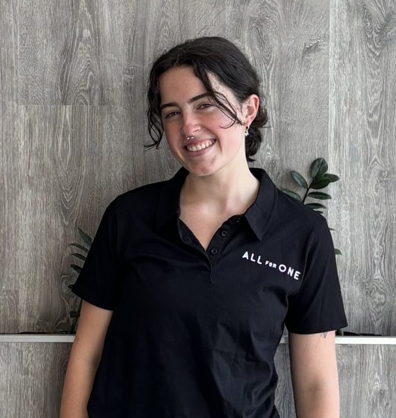 Team member in an All for One polo shirt at the studio