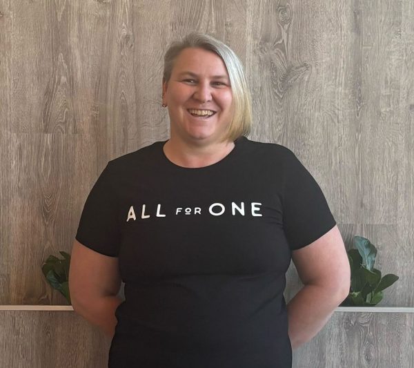 Team member in an All for One tee at the studio