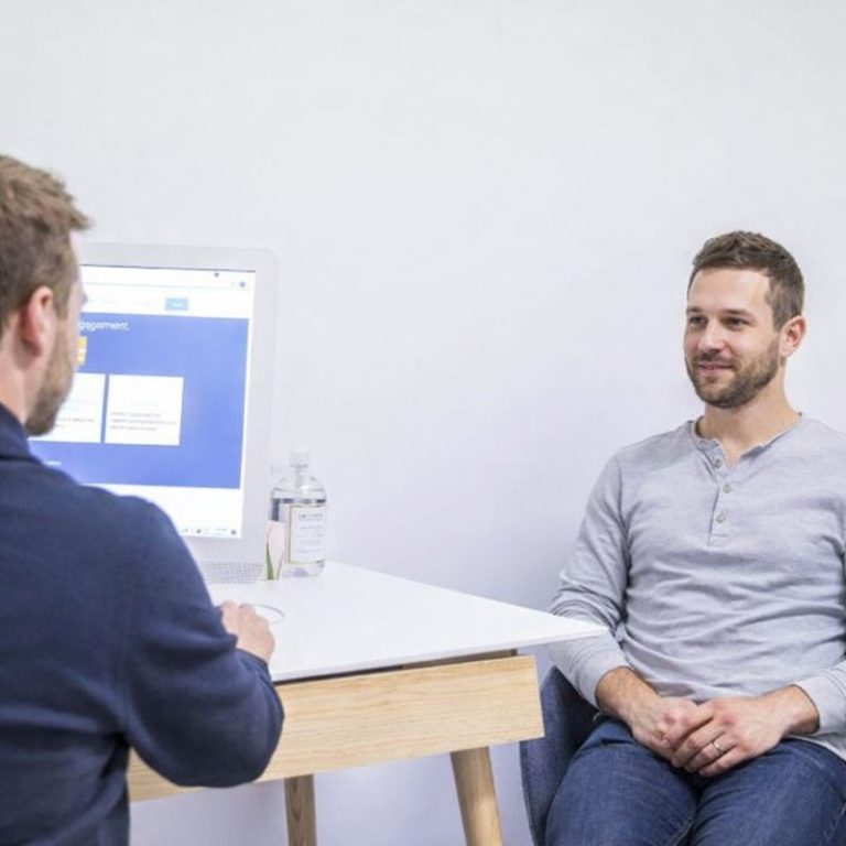 Melbourne physiotherapist talking through low back pain with a client at All for One studio