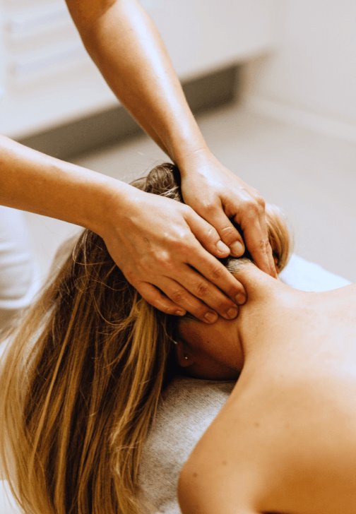 A therapist working on a members neck and shoulders at All for One