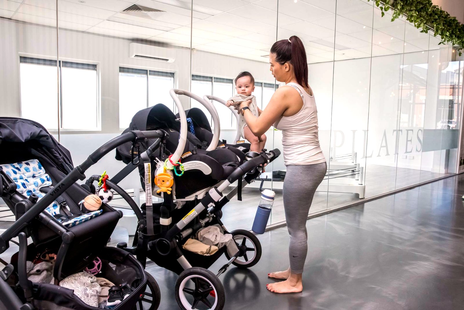 A physiotherapist settling a baby while coaching a Mums and Bubs class at All for One