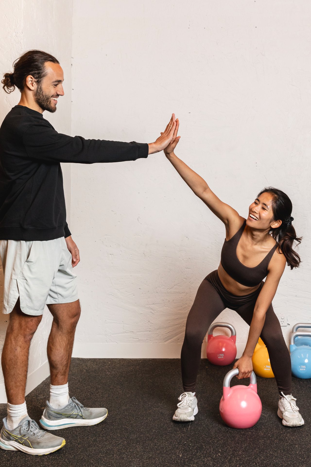 A trainer coaching a member's lifting technique at All for One