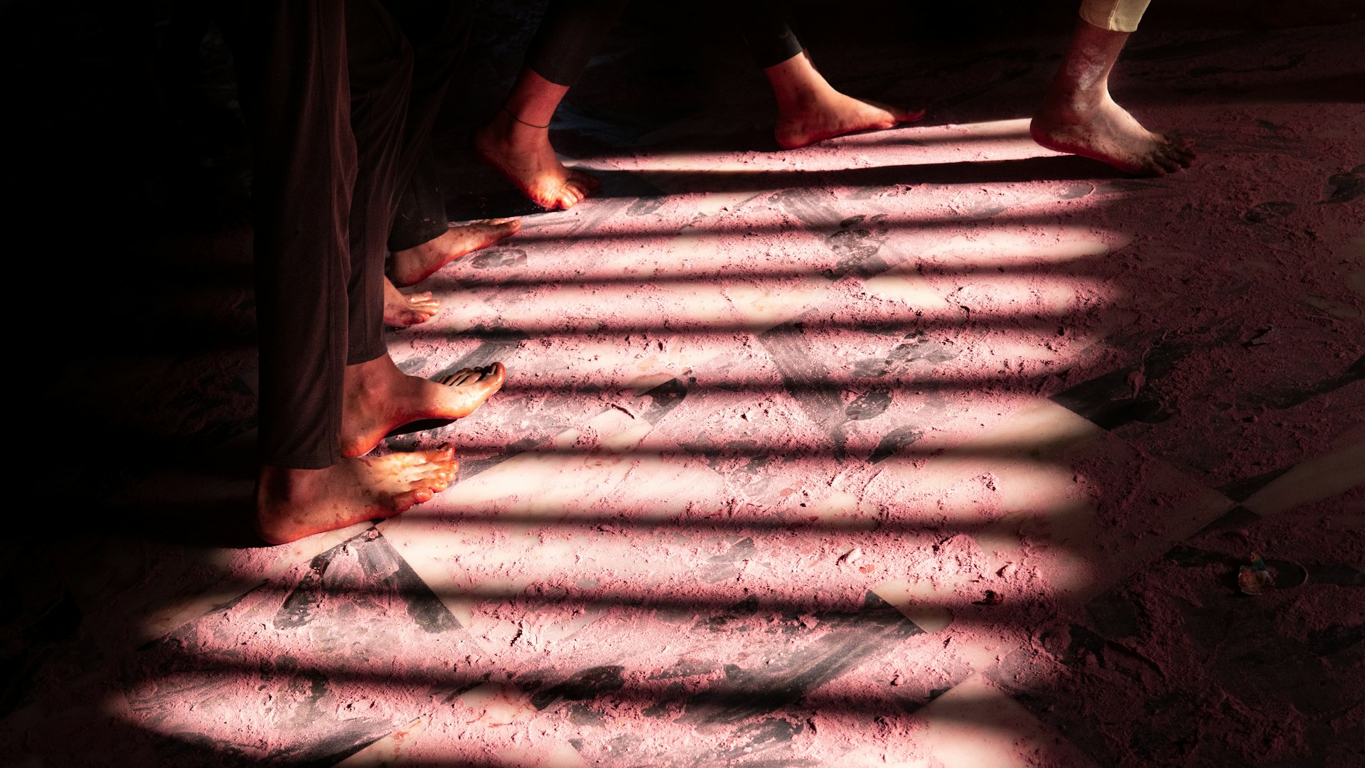 Bare feet walking across a floor in striped morning light